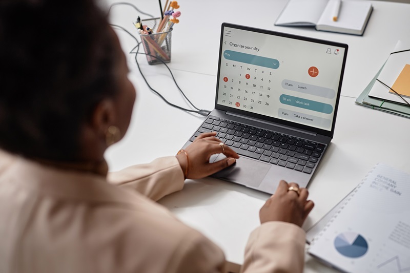 Laptop Screen with Calendar Page and Typing Black Woman