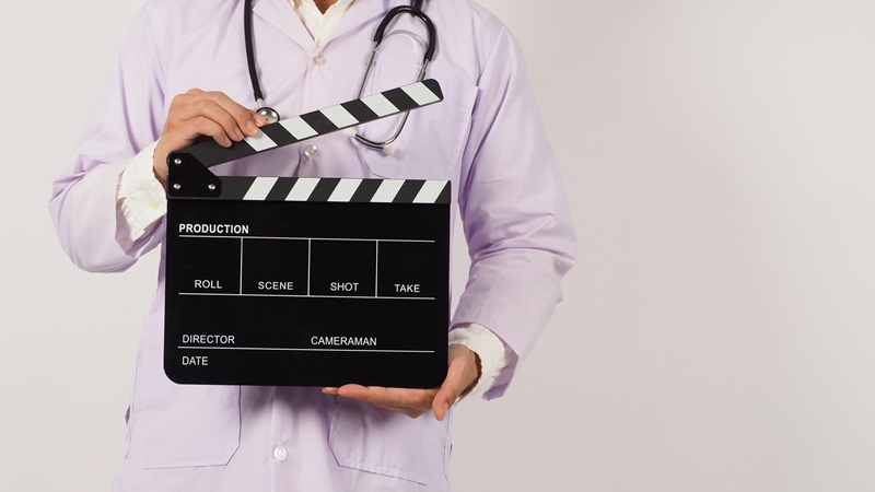 Doctor's holding Black Clapper board in hand on white background