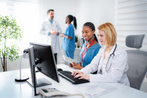 Medical team reviewing patient information together on a desktop computer in a modern clinic office